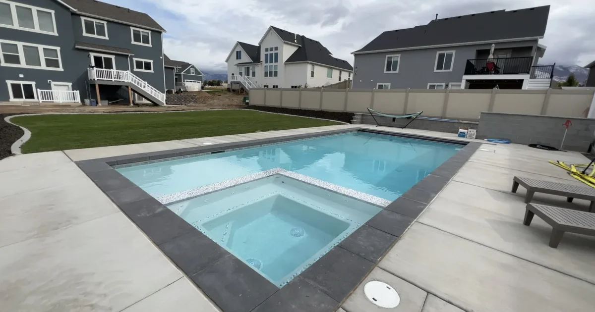 Finished custom backyard pool with attached spa and decking at a Utah County home