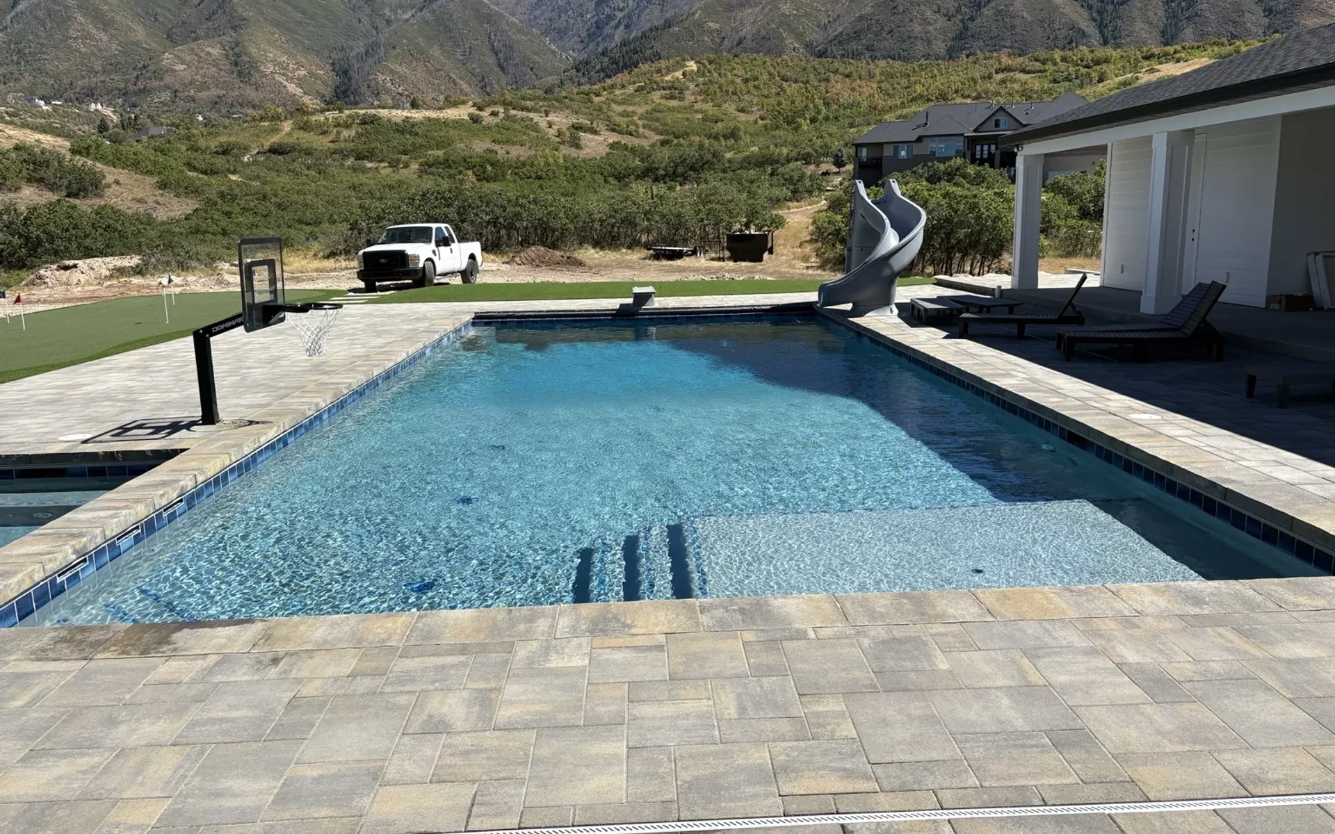 Custom gunite pool with attached spa and decking in a Utah County backyard