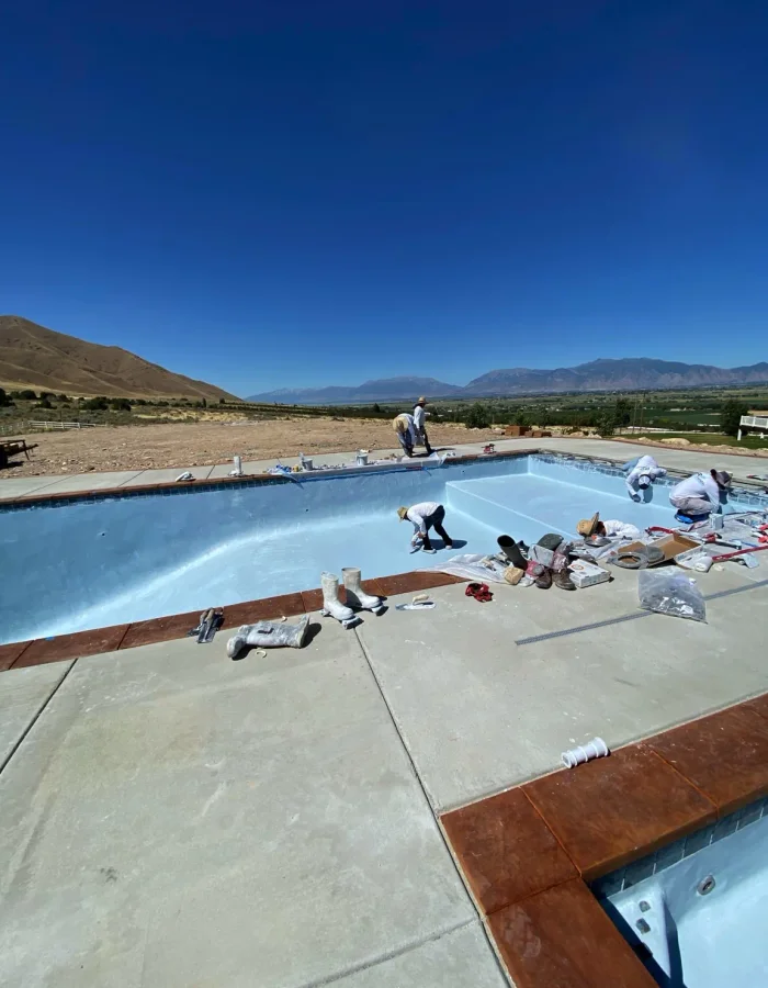 Plaster finishing crew working on a custom concrete pool in West Mountain Utah